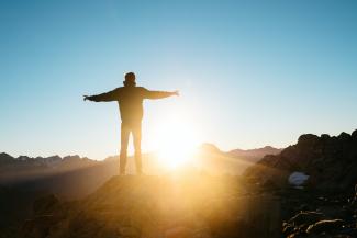 person standing on hill by Pablo Heimplatz courtesy of Unsplash.