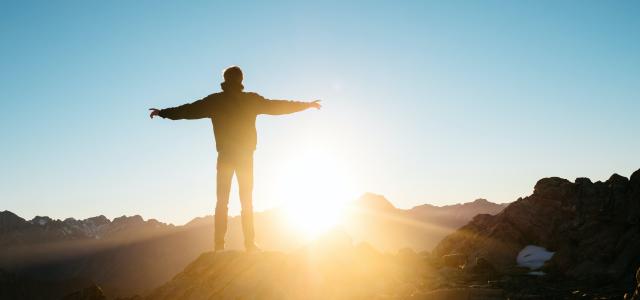 person standing on hill by Pablo Heimplatz courtesy of Unsplash.